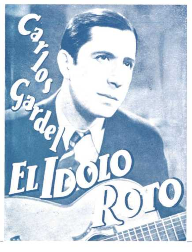 Ein Plakat mit El Idolo Roro, einem spanischen S├Ąnger und Songwriter, der eine Gitarre h├Ąlt, ein wei├čes Hemd und einen schwarzen Anzug tr├Ągt, mit zur├╝ckgek├Ąmmtem Haar und einem ernsten Gesichtsausdruck, vor einem hellblauen Hintergrund mit fetter schwarzer Schrift.