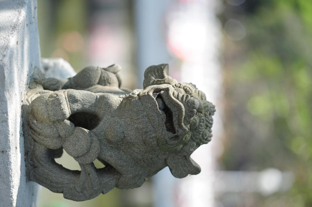 Eine Skulptur steht in der Mitte mit Pflanzen und Lichtern im Hintergrund.