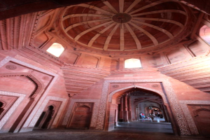 Ein Innenblick eines monumentalen Gebäudes mit Menschen, die auf dem Boden gehen und stehen.