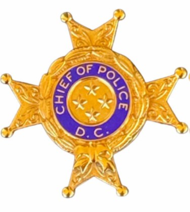 Polizeimarke mit 'Polizeipräsident' auf weißem Hintergrund.