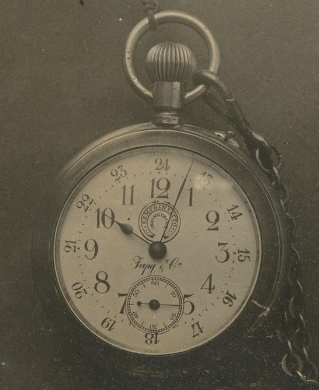 Altes Schwarz-Weiß-Foto einer Taschenuhr mit einer Kette, mit einer nummerierten Ziffernblättern.