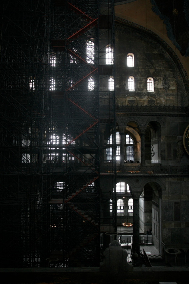Ein Gebäude mit mehreren Fenstern, Eisengittern und einer Treppe, die zum Eingang führt.