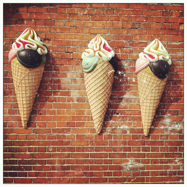 Eiskrem-Könige und -Becher sind an einer Wand angebracht.