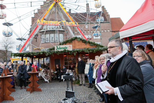 Eine Gruppe von Menschen steht vor einem Cafe mit einer Tafel, auf der 'Ruskin's Cafe' steht.