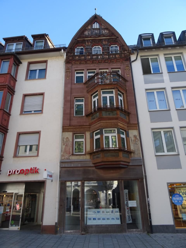 Gewerbliches Gebäude mit vielen Fenstern zum Verkauf in Heidelberg, Deutschland, unter einem klaren blauen Himmel.