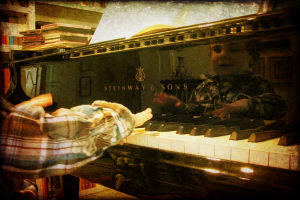 Ein Kind sitzt an einem Klavier und spielt die Tasten.