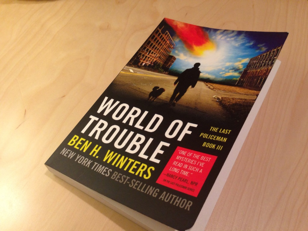 Ein Buch mit dem Titel "Welt der Probleme", das ein Bild eines Mannes und eines Hundes zeigt, das auf einem Tisch liegt.