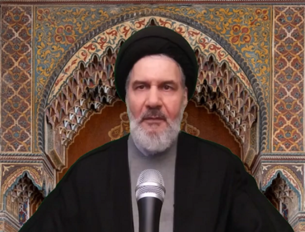 Ayatollah Ali Khamenei, der Oberste Führer von Iran, trägt ein schwarzes Gewand und eine schwarze Mütze und spricht in ein Mikrofon vor einer Wand mit kunstvollen Verzierungen.