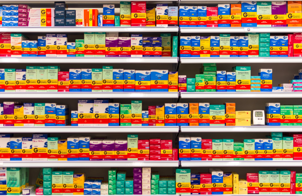 Ein Apothekenregal voller verschiedener Medikamente, darunter Schachteln, ordentlich auf den Regalen angeordnet.