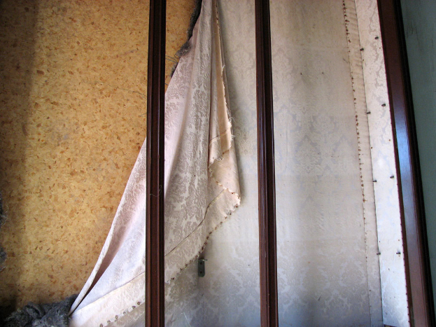 Eiserne Pfosten, Vorhang und eine Wand im Vordergrund.