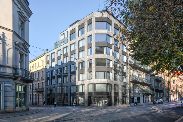 Großes mehrstöckiges Bürogebäude mit zahlreichen Fenstern, umgeben von Straßeninfrastruktur, Fahrzeugen, Fußgängern, Bäumen und einem bewölkten Himmel, das als neues Firmensitz dient.
