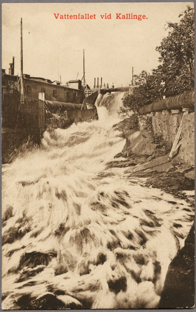 Altes Schwarz-Weiß-Foto eines Flusses unter einer Brücke mit Bäumen, Gebäuden, Strommasten und einem Zaun entlang des Ufers; Text erscheint oben.