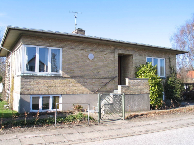 Ein frei stehendes Zweifamilienhaus mit zwei Schlafzimmern zum Verkauf in St Johns Road, St Johns Wood, Swindon, mit einem Dach, Fenstern, Tür, Treppe, Metallzaun, Pflanzen, Gras, Bäumen, einer Satellitenschüssel und einem bewölkten Himmel.