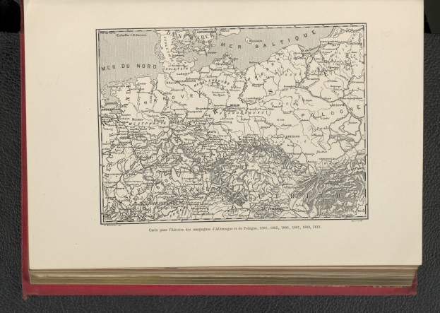 Ein aufgeschlagenes Buch, das eine detaillierte Karte von Deutschland zeigt, die auf einer schwarzen Oberfläche liegt.