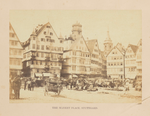 Ein altes Foto eines belebten Marktes in Stuttgart, Deutschland, mit zahlreichen Gebäuden, Menschen, Karren und verschiedenen Gegenständen sowie einem Text am unteren Bildrand.
