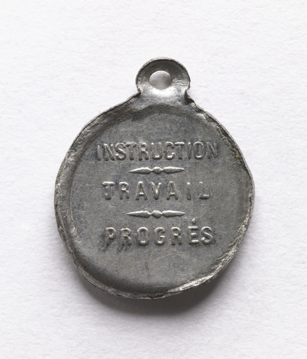 Eine Silbermedaille mit der Aufschrift "Instruction Travail Progress" auf einem weißen Hintergrund.