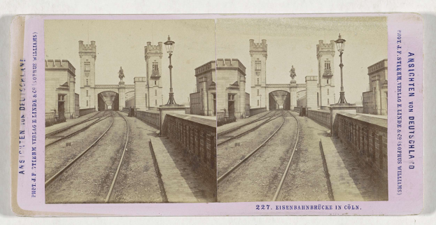 Schwarz-weißes stereoskopisches Foto einer Eisenbahnbrücke in Köln, Deutschland, mit Eisenbahnschienen, Wänden, Pfählen, Statuen, Himmel und Text.