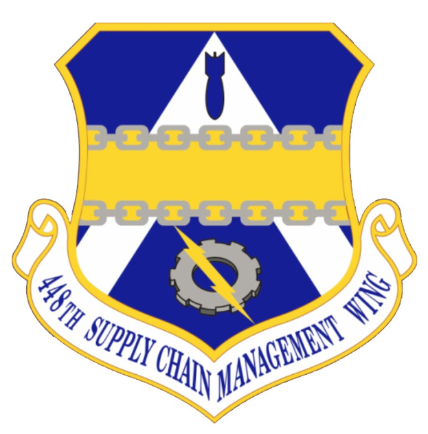 Logo des 48. Versorgungsgeschwader mit einem blauen Schild mit einem weißen Stern und einem weißen Banner mit der Aufschrift "Versorgungsgeschwader" in blau, alles umrandet von einem weißen Rand und schwarzer Schrift.