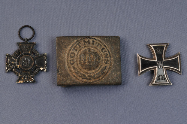 Drei Eisernes Kreuz-Medaillen, zwei Deutsche Eisernes Kreuz und eine weitere, alle mit Inschriften, symbolisieren Tapferkeit, Mut und Opfer, die von deutschen Militärpersonal während des Zweiten Weltkriegs gebracht wurden.
