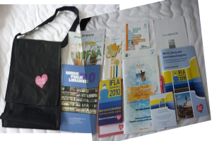 Eine Tasche mit den Worten "Bücherliebhaber" und einigen Büchern auf einem Bett.