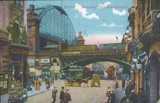 Alte Ansichtskarte zeigt eine belebte Stadtstraße in Berlin, Deutschland mit Fußgängern, Pferdewagen, Gebäuden, Laternen, einer Brücke und einem bewölkten Himmel mit Text oben.
