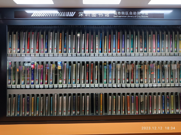 Eine gut beleuchtete Bibliothek mit hohen Bücherregalen voller Bücher, ein Textschild und ein Wasserzeichen unten.