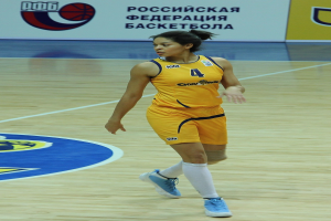 Ein professioneller Basketballspieler in gelber Uniform, der auf einem Court dribbelt, mit einer Tafel im Hintergrund.