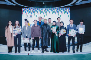 Gruppe von Menschen auf einer Bühne mit Blumensträußen und Urkunden vor dem Hintergrund 'Youth Solar Awards 2019'.